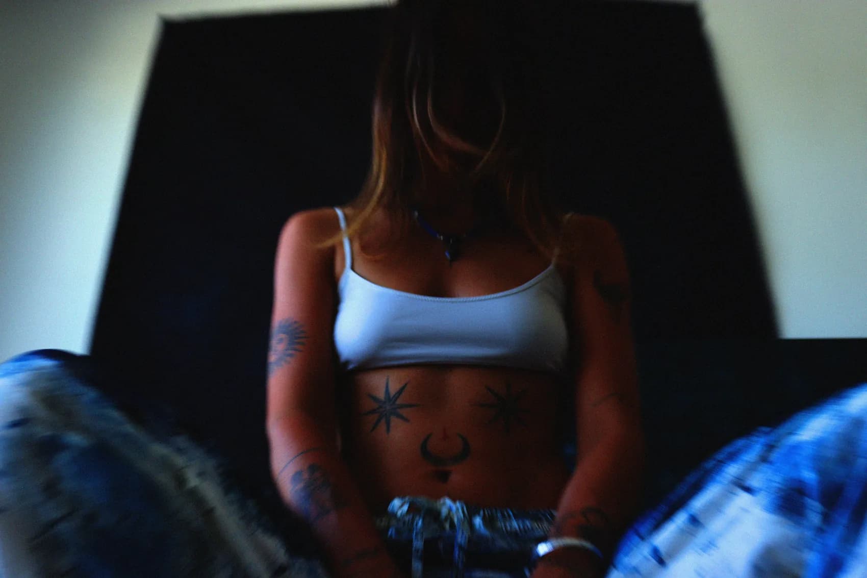 Devant la toile noire, les tatouages du ventre