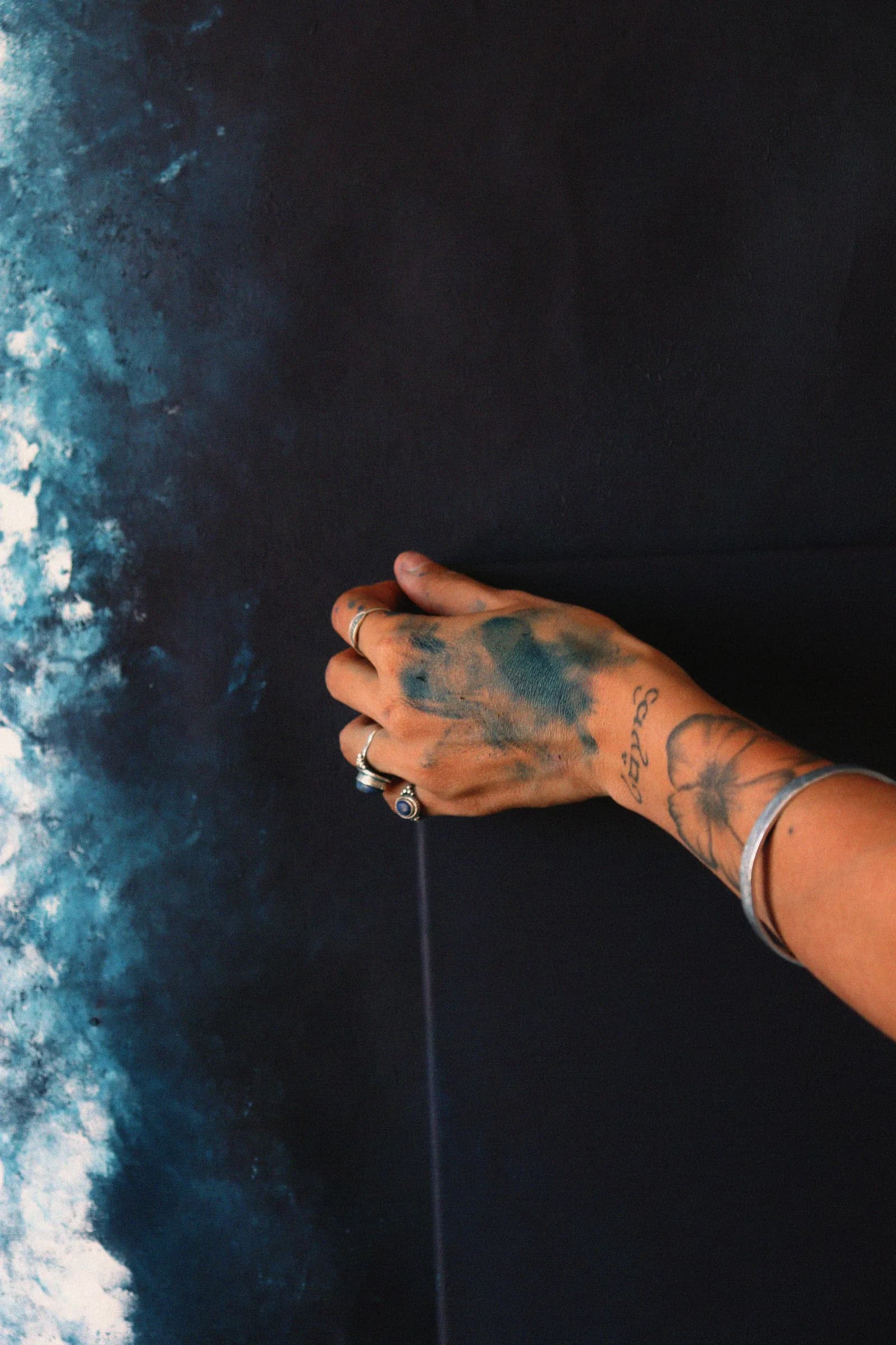 Ma main couverte de bleu, posée à même la toile