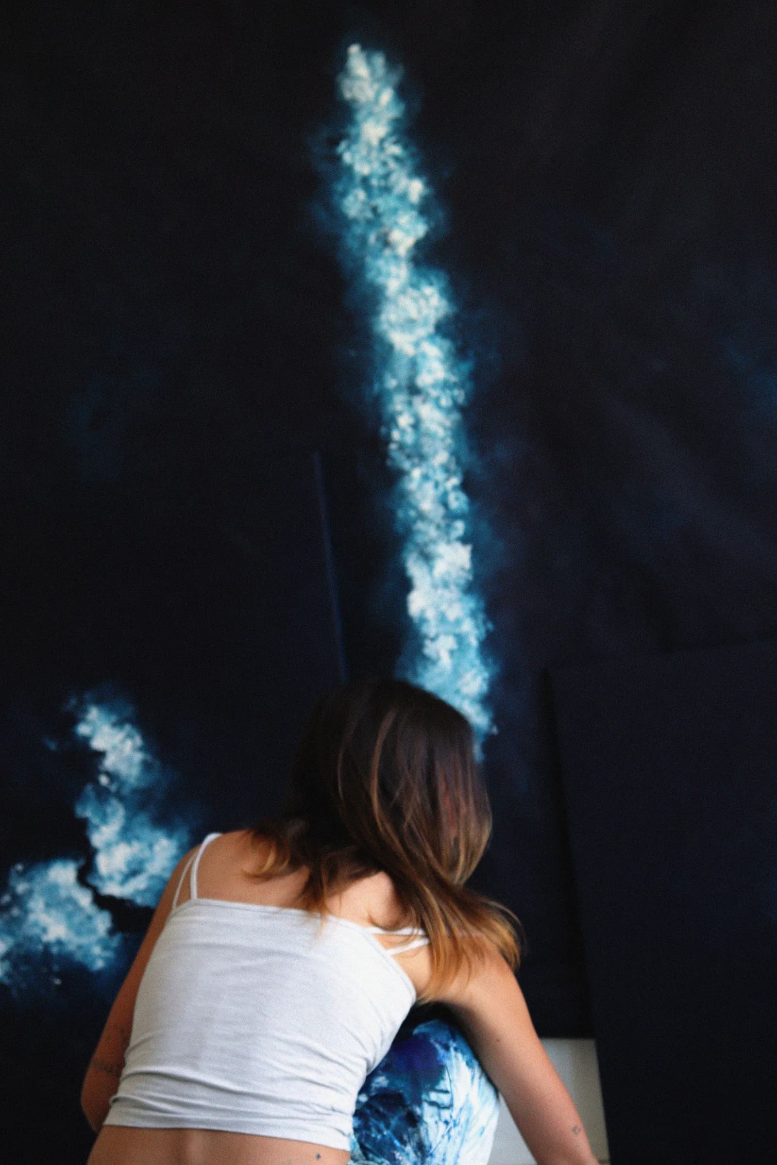 Penchée vers une grande toile, l'écume bleue au-dessus de moi