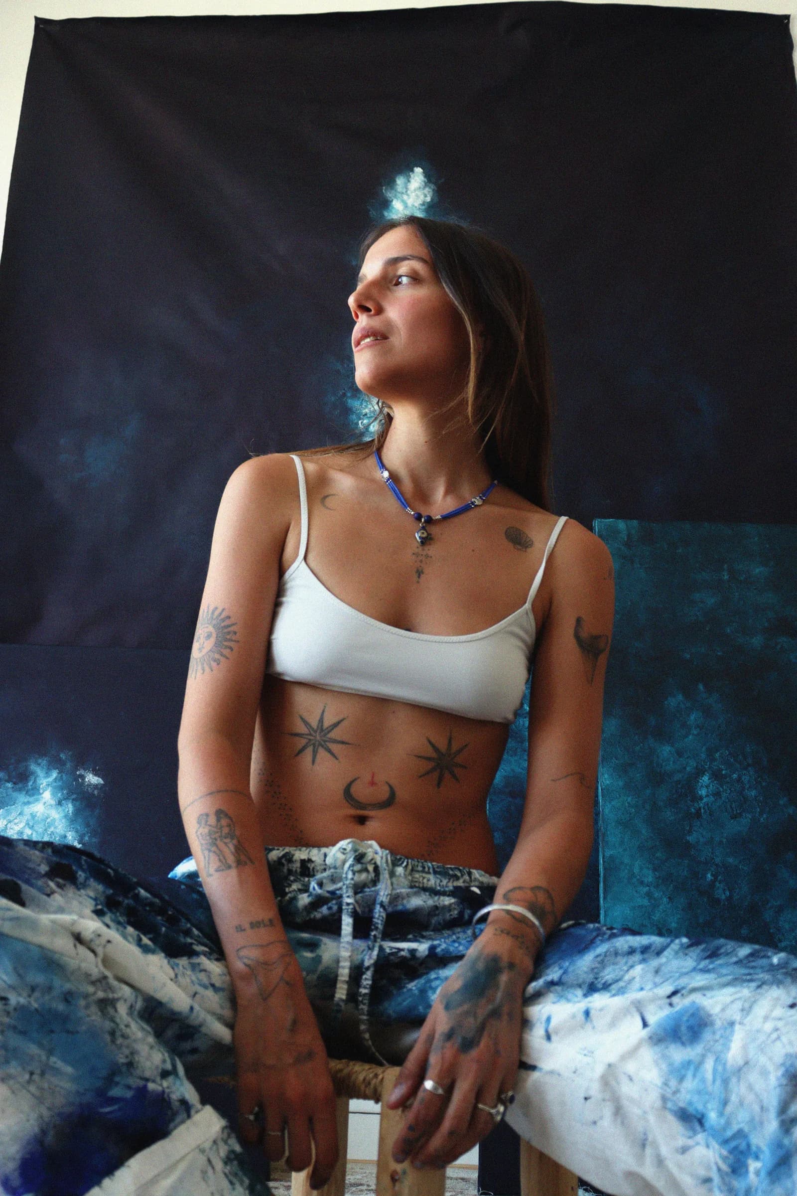 Assise devant mes toiles bleues, dans l'atelier