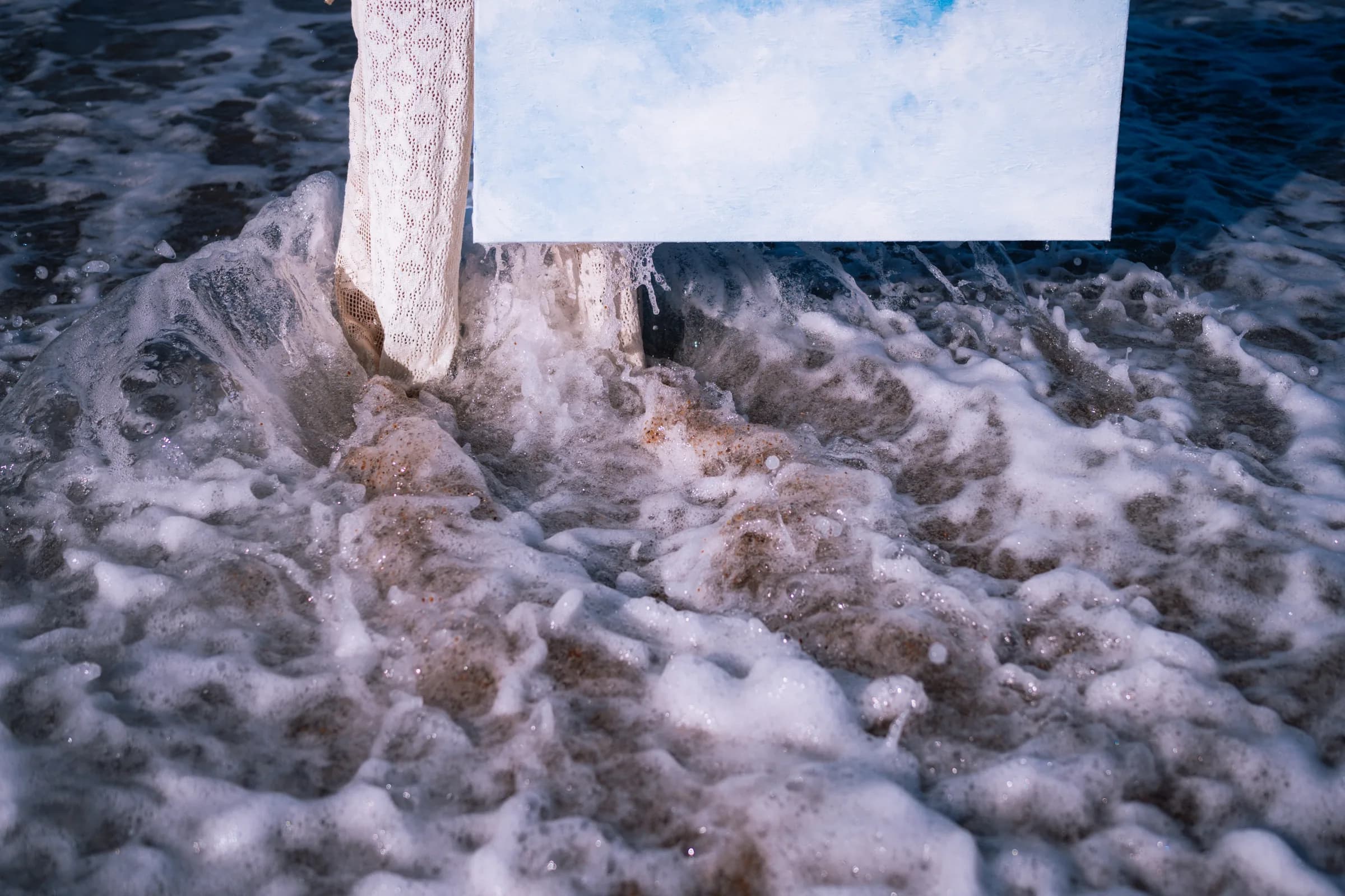L'écume et le bas de la toile, au ras de l'eau