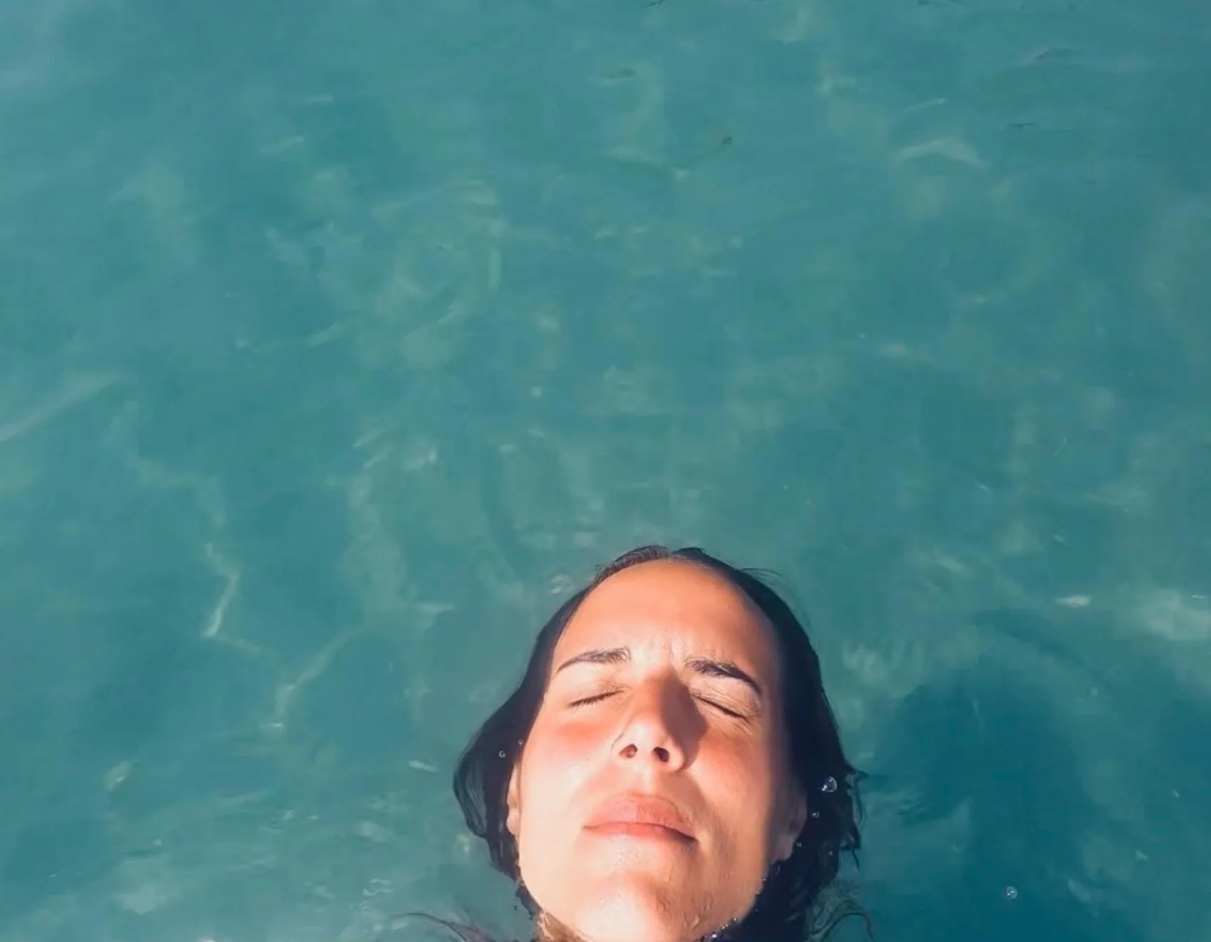 Le visage tourné vers le ciel, dans l'eau au large de Crozon