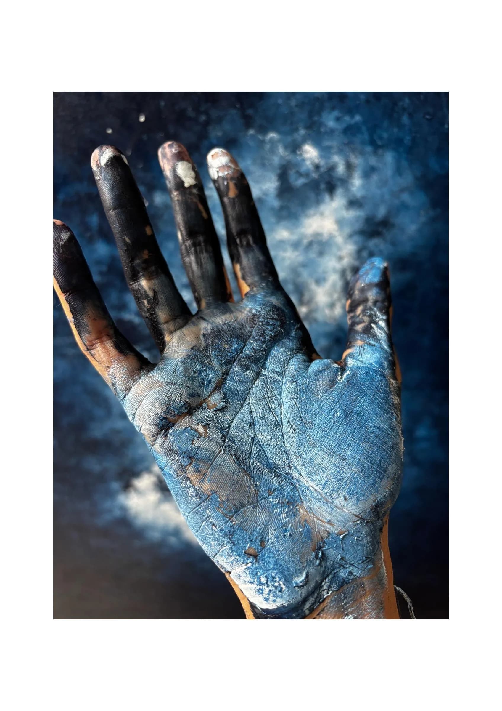 Ma main couverte de peinture bleue et noire